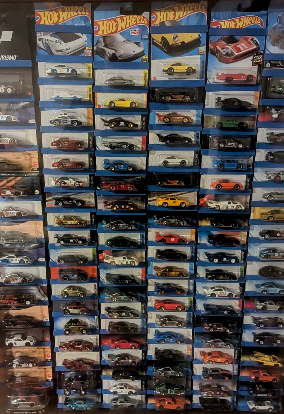 Card-Tacs display bars mounted on wall showcasing 100+ Hot Wheels collectibles in original packaging